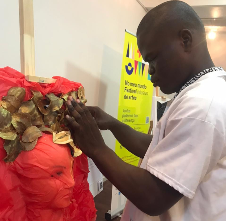 Visitante explora, com o tato, uma das obras expostas